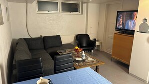 Un espace de vie compact comprenant un canapé, une petite table basse et un téléviseur.