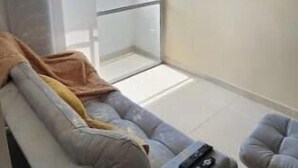 Un soggiorno moderno con un divano, un telecomando e una TV a parete.