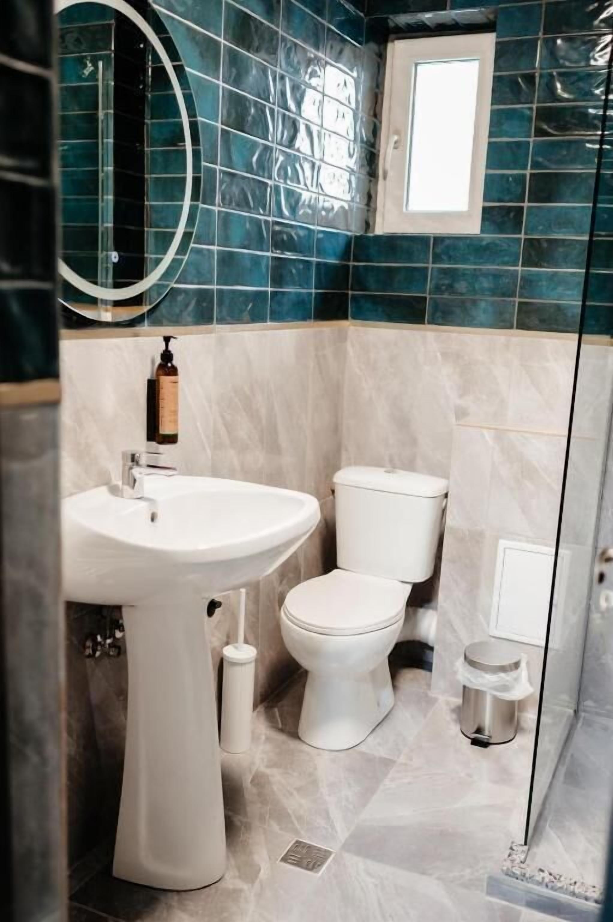 Un baño con lavamanos, inodoro y ducha blancos.