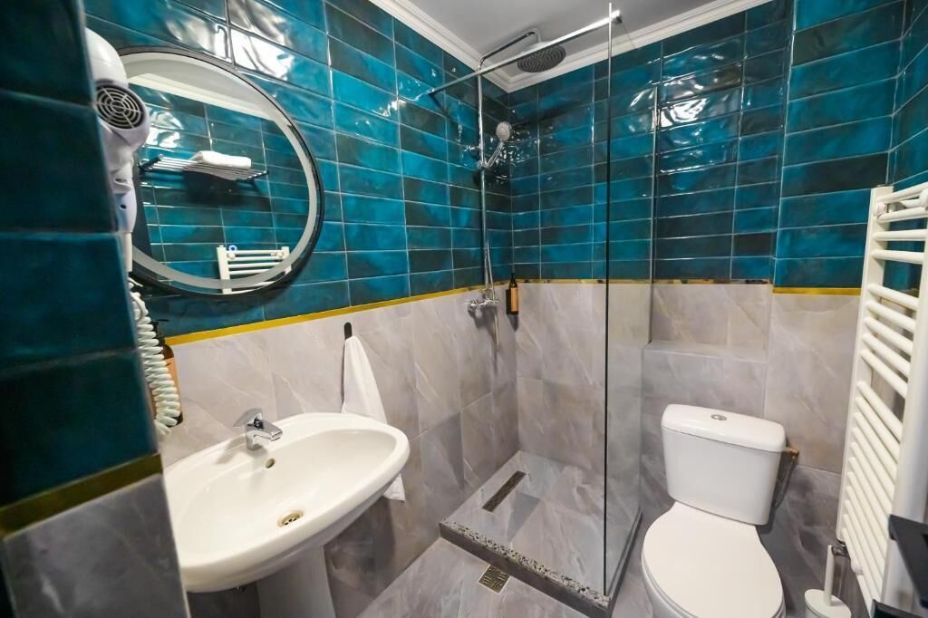 Een badkamer met een wastafel, toilet en douche.