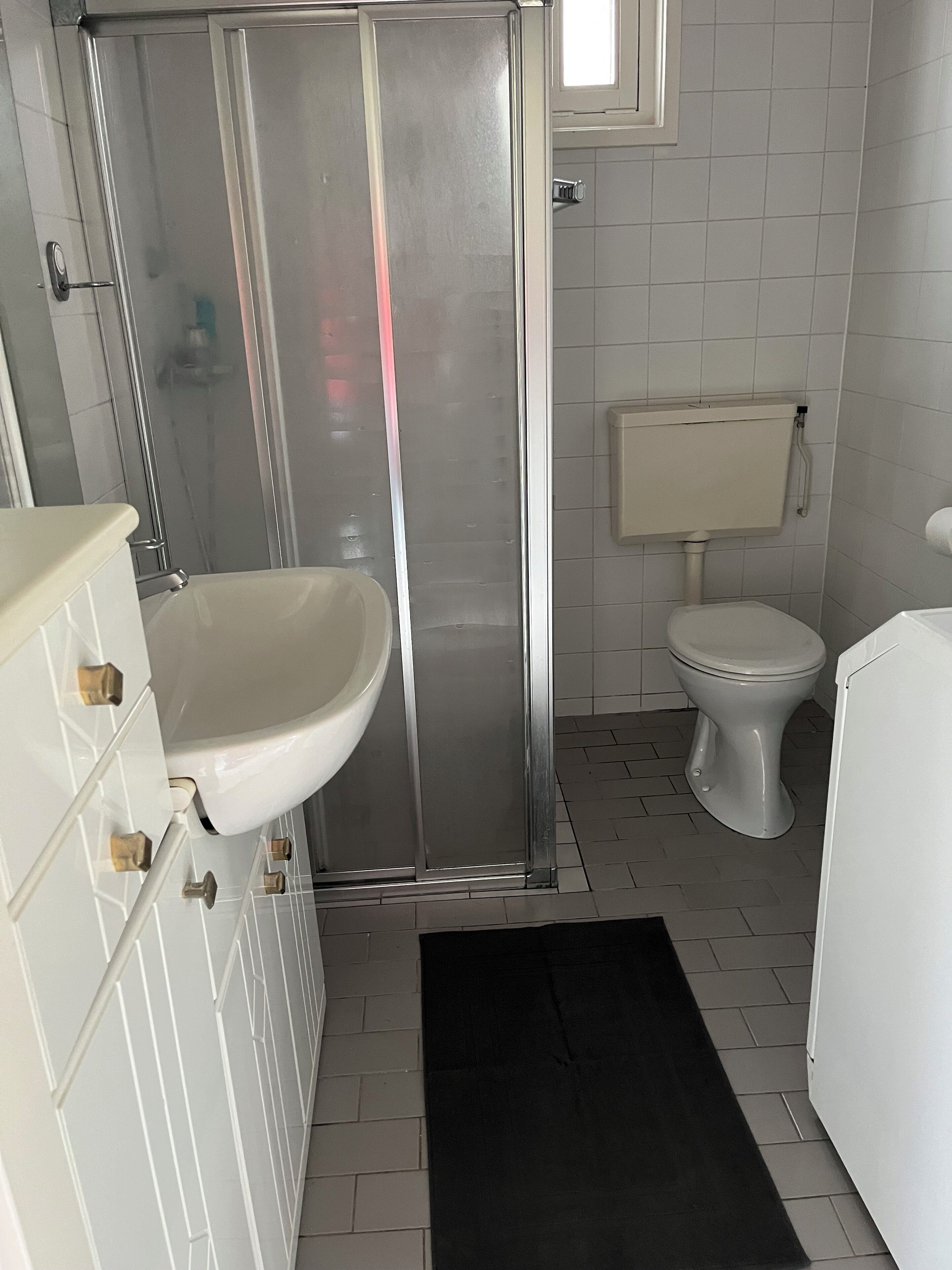 Une salle de bain équipée d’une douche, de toilettes et d’un lavabo.