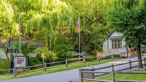 A rural road with a wooden fence, a stone building, and a sign indicating 'Powder Horn Mountain' and 'Chapel'. - Smore than enough! Powder Horn Mountain - 3K,2 twin bunks, Pets OK,Pool table (Deep Gap)