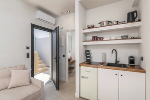 Eine kleine Küche mit Spüle, Schränken und einer Kaffeemaschine.