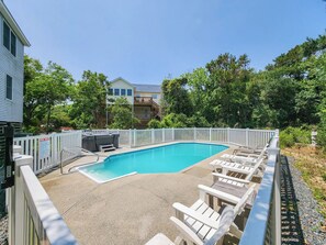 A swimming pool with a white fence, lounge chairs, and a hot tub. - Pirate's Cove - 5 BR Oceanside Home w/Private Pool & Hot Tub, 300 Yards to Beach Access (Southern Shores)