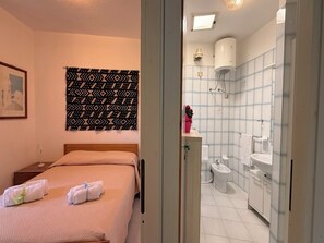 Un dormitorio con una cama, una mesita de noche y un tapiz de pared.