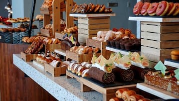 A variety of pastries and desserts displayed on wooden stands.