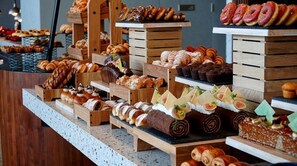A variety of pastries and desserts displayed on wooden stands. - Rotana Ras Al Khaimah - The Mangroves (Ras Al Khaimah)