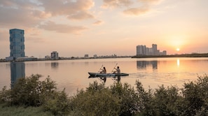 A calm river with a city skyline in the background, including modern high-rise buildings. - Rotana Ras Al Khaimah - The Mangroves (Ras Al Khaimah)