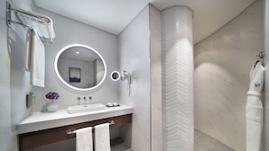 A modern bathroom with a vanity, mirror, towel rack, and shower. - Rotana Ras Al Khaimah - The Mangroves (Ras Al Khaimah)