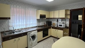 Cocina compacta con lavadora, microondas y fregadero.