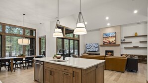 A spacious kitchen with wooden cabinets, a central island, and pendant lighting. - Luxe Caldera Escape w/ Forest Views, Private Hot Tub, Sauna, Game Room, Seasonal Pool, Bikes & More! (Bend)