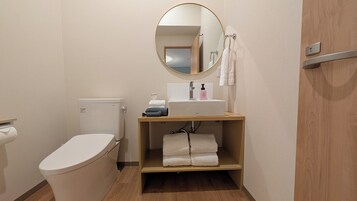 Un baño pequeño y limpio con inodoro, lavamanos y espejo.