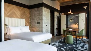 A hotel room with two beds, a marble wall, a wooden ceiling, and a dining area with a table and chairs. - Exquisite Room Tailored for Families – Great Central Location (Rotterdam)