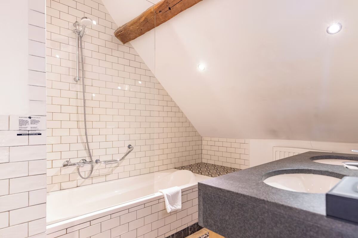 Une salle de bain moderne avec une baignoire, une douche et deux lavabos.