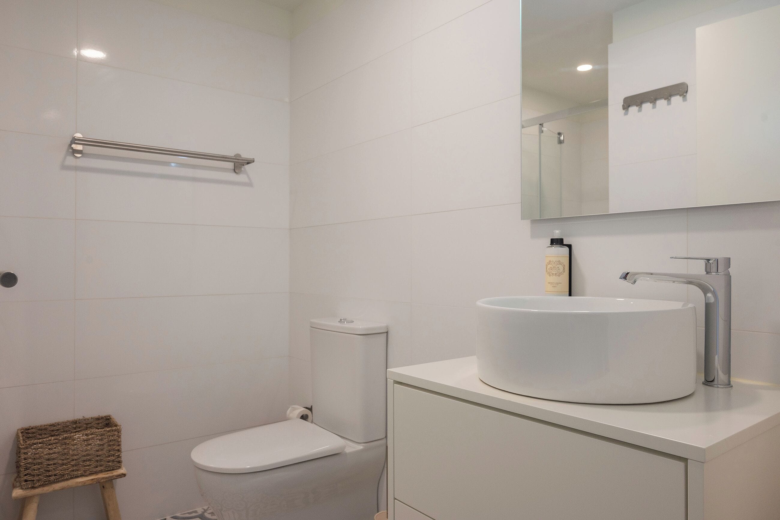 Ein modernes Badezimmer mit Toilette, Bidet und Waschbecken mit Spiegel darüber.