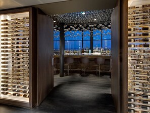 A bar area with shelves of bottles, a bar counter, and stools. - Perfect Getaway close to local attractions, Keukenhof, Golf & Nature escape (Amsterdam)