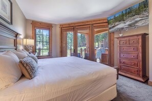 A bedroom with a large bed, wooden headboard, a dresser, and a view of a balcony. - New Listing! Village at Northstar Residence - Big Horn 412 (Truckee)