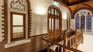 A staircase with wooden railings and stained glass windows.
