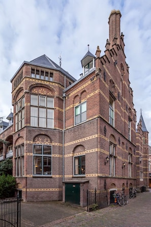 A historic building with a prominent tower, large windows, and a brick facade.