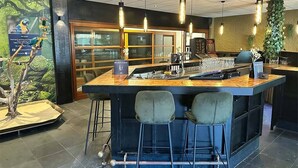 A bar area with a central island, bar stools, and hanging pendant lights. - 3 Units | Group Friendly Callanstoog Stay, Beach Adventures, Golf & Pool Access (Callantsoog)