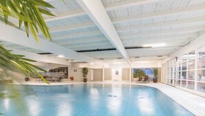 An indoor swimming pool with clear blue water, surrounded by a tiled floor and walls. There are lounge chairs and potted plants around the pool area. - 3 Units | Group Friendly Callanstoog Stay, Beach Adventures, Golf & Pool Access (Callantsoog)