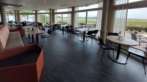 A spacious indoor area with multiple seating options including tables and benches, large windows offering a view of the outdoors. - Relaxing Haamstede Haven | beach escape, Scenic Nature trails, Local attractions (Burgh-Haamstede)