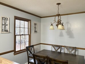 A dining room with a wooden table and chairs, a chandelier, and decorative wall art. - Peaceful 3-bedroom house with AC in charming Easley (Easley)