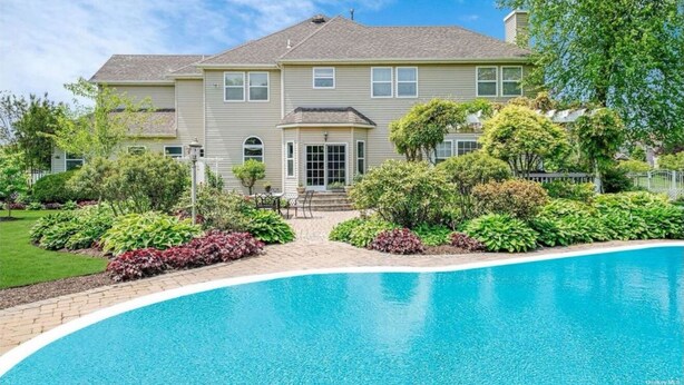Una casa de dos pisos con piscina delantera.