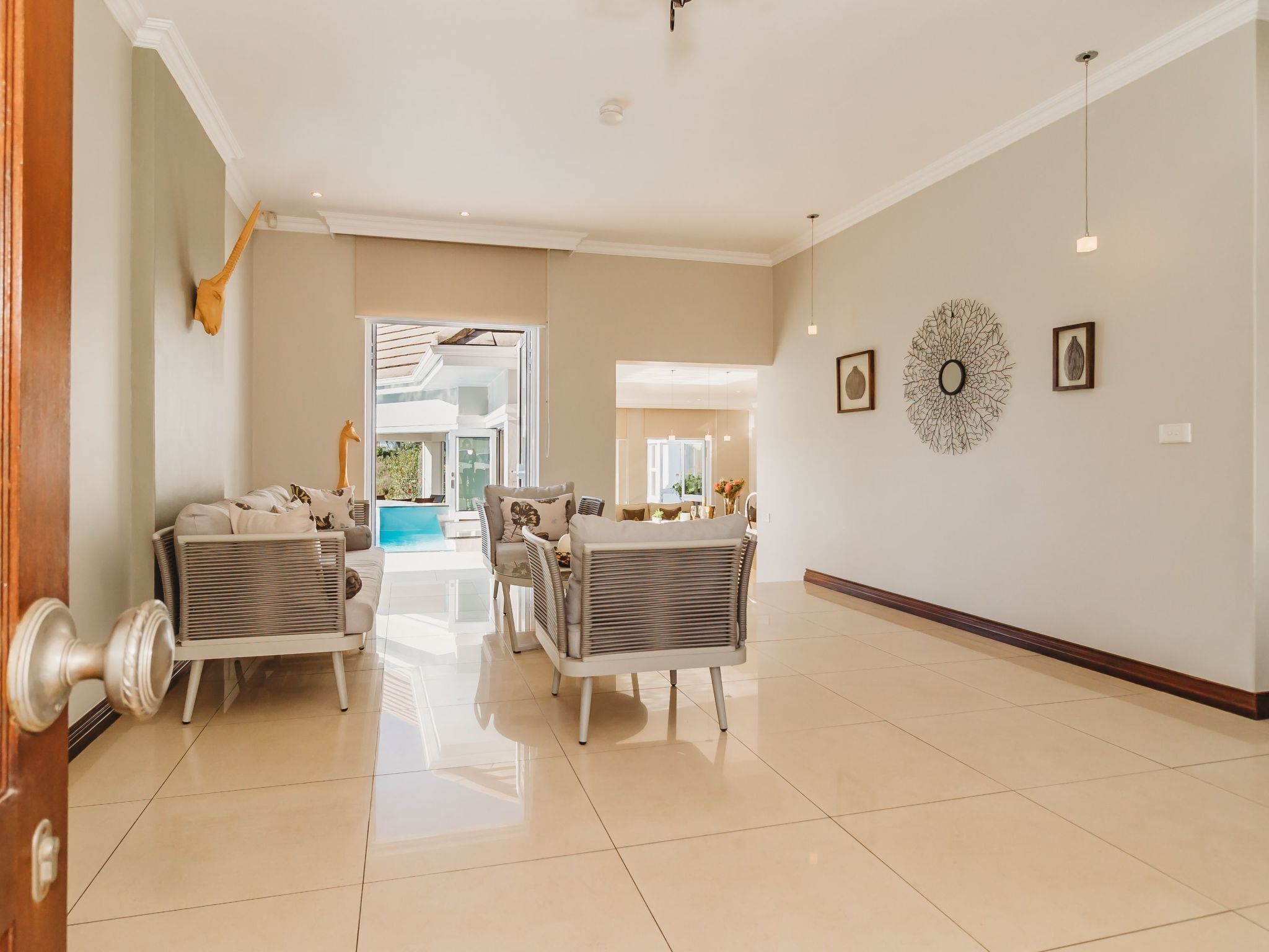 A spacious living area with a pool view, modern furniture, and decorative wall art.