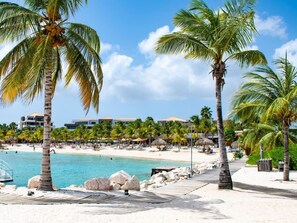 A beach resort with palm trees, a pool, and a sandy beach. - Reef 5 Blue Bay, Strand Golf Meerblick, Curacao by Interhome (Willemstad)