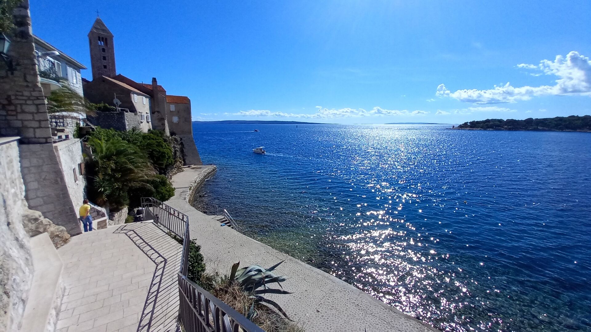 Un pueblo costero con una iglesia destacada y una vista despejada del mar.