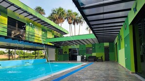 A swimming pool with a tiled deck and a covered area with green walls and a roof. - Encanto Llanero by Interhome (Villavicencio Meta)