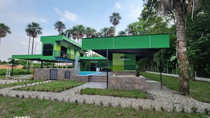 A modern two-story house with a green exterior, a swimming pool, and a stone patio. - Encanto Llanero by Interhome (Villavicencio Meta)