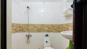 Un baño pequeño con inodoro, ducha y lavamanos.