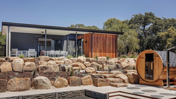 A modern house with a sauna, stone walls, and a patio with outdoor furniture. - ESCAPE TO PICTURESQUE EAGLE BAY IN THIS BEAUTIFULLY APPOINTED 2 BED STUDIO (Eagle Bay)