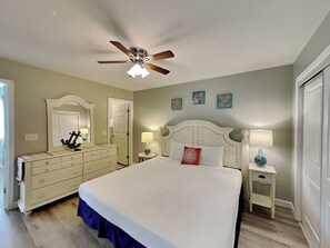 A bedroom with a bed, dresser, nightstands, and a ceiling fan. - Gulf Highlands #195 | Across from Beach + Amenities! (Panama City Beach)