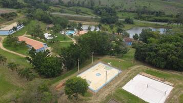 Vista aérea de una zona residencial con un espacio abierto amplio, una piscina y una cancha de baloncesto.