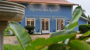A building with a blue facade and a tiled roof, named "Quinta das Águas." - Quinta das Águas by Summit Hotels (Itapira)