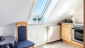 Eine kleine Küche mit Oberlicht, einem Esstisch mit Stühlen und einer Kaffeoecke.
