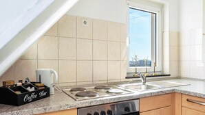 Eine Küche mit Kaffeebereich, Herd, Backofen und einem Fenster mit Aussicht.