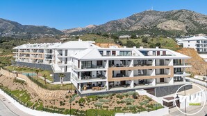Et moderne, moderne hotel med flere etager, med altaner, pool og anlagt have.