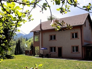 A two-story house with a tiled roof, a small porch, and a dining area with outdoor furniture. - Vila Roberta Breaza Brasov by Interhome (Brașov)