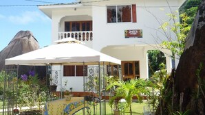 Un edificio de dos pisos con un balcón, un área de estar al aire libre techada y un letrero que dice 'Josie's Cottages'.