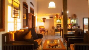 A cozy living room with a sofa, armchairs, and a coffee table. There is a dining area with a table and chairs, and a kitchen in the background. - Villananda by Interhome (Ambalangoda)
