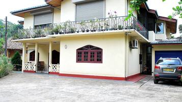 A two-story house with a balcony, a garage, and a front porch.