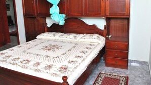 A bedroom with a wooden bed, a canopy, and a nightstand. - Dominic's Home by Interhome (Weligama)