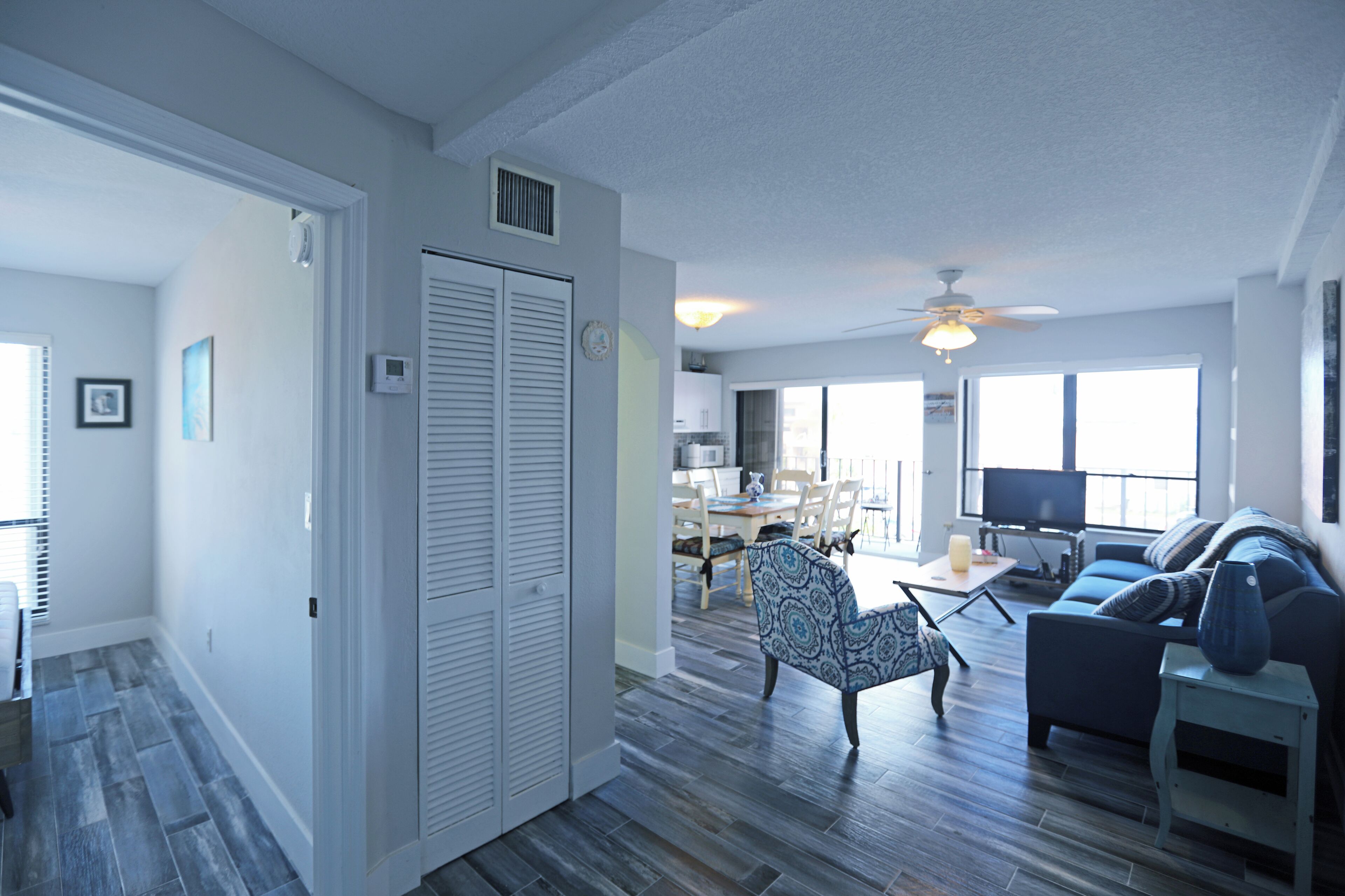 A spacious living area with a dining table, chairs, a sofa, and a television.