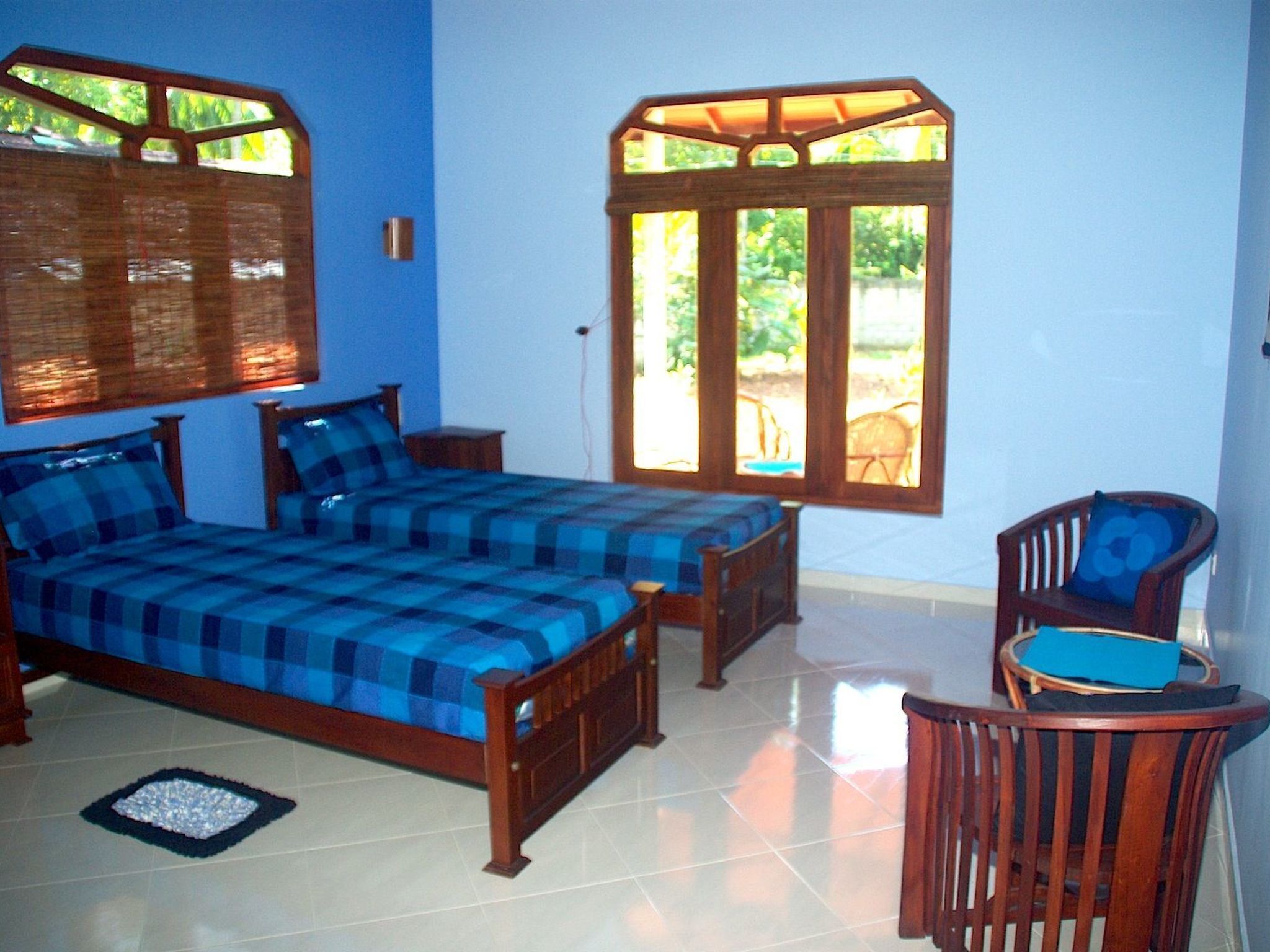 A bedroom with a bed, a chair, a window, and a door.