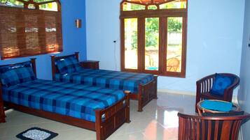 A bedroom with a bed, a chair, a window, and a door.