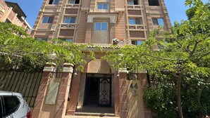 A multi-story building with a symmetrical facade, featuring a central entrance with a decorative gate, and balconies on each floor. - Wohnung "Zayed Continental G" by Interhome (Cairo)